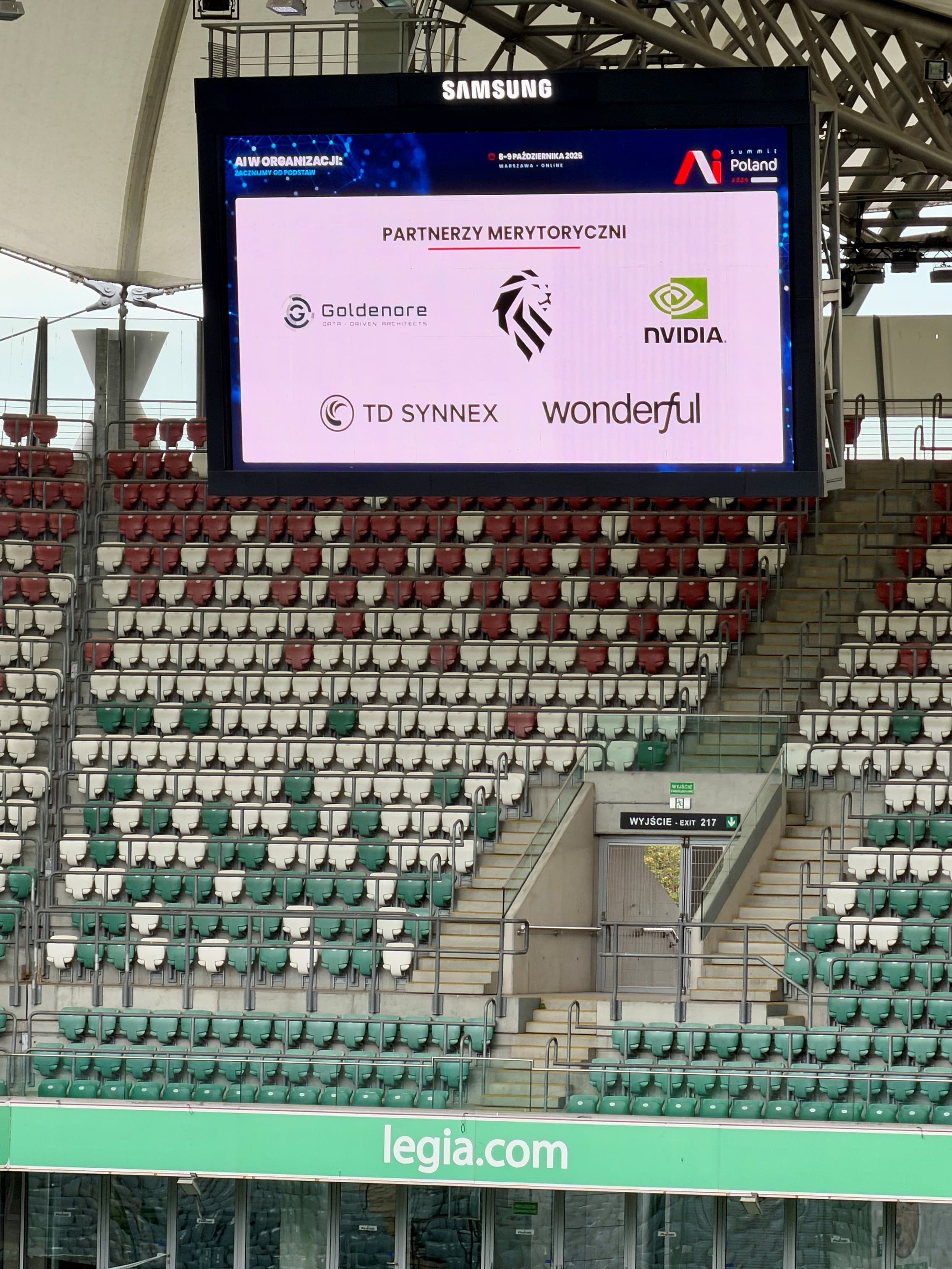 Goldenore among the AI Summit Poland 2026 content partners on the stadium screen