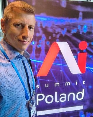 Piotr Boguszewski beside the AI Summit Poland 2026 sign